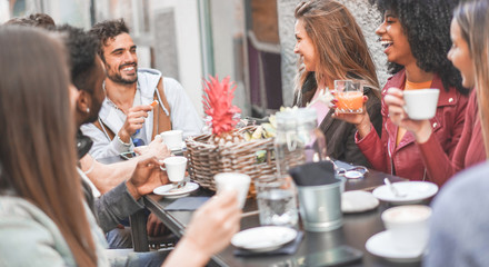 Group of happy friends drinking coffee and cappuccino at vintage bar outdoor - Focus on blond top girl face