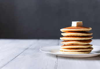 fresh classic pancake stacked in stack on gray background with place for text - obrazy, fototapety, plakaty
