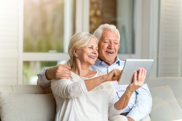 Senior couple using digital tablet at home
