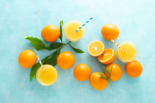 Orange freshly squeezed juice in glass and fresh fruits on a blue vivid background, top view © Sea Wave