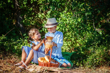 Children's picnic eco products outdoors in the Park boy and girl with bread and milk