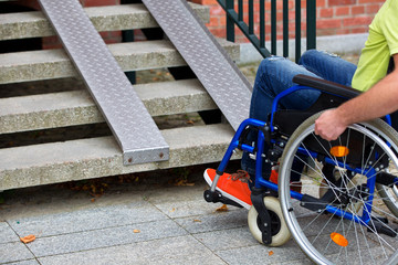 man on wheelchair trying to go up the stairs - 259108301