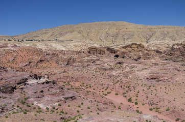 Ruin of Moghar Annassara (Christian Tombs )  in Petra and Uum Sayhoun village at background and dry watercourse of Wadi Mataha river , Jordan