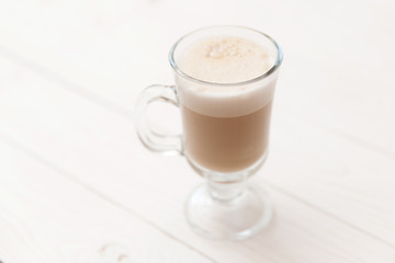 Raf coffee in transparent glass on a light wooden background. Delicious Russian most popular drinks. 