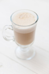 Raf coffee in transparent glass on a light wooden background. Delicious Russian most popular drinks. 