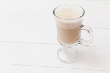 Raf coffee in transparent glass on a light wooden background. Delicious Russian most popular drinks. 