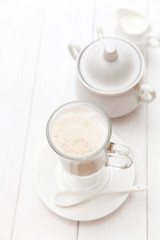 Raf coffee in transparent glass on a light wooden background. Delicious Russian most popular drinks. 