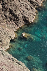 Fototapeta na wymiar Cinque Terre, Liguria, Italy. Rocks overlooking the blue sea. The sea coast of the Five Lands with rock walls and rocks