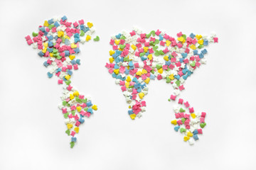 Colorful sugar sprinkles in world map shap on a white backgrounde, top view. Creative collection