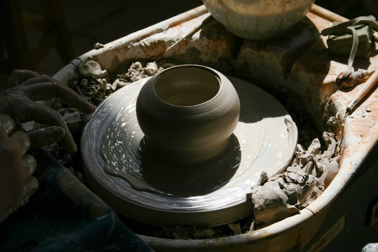 Hands of potter making clay pot