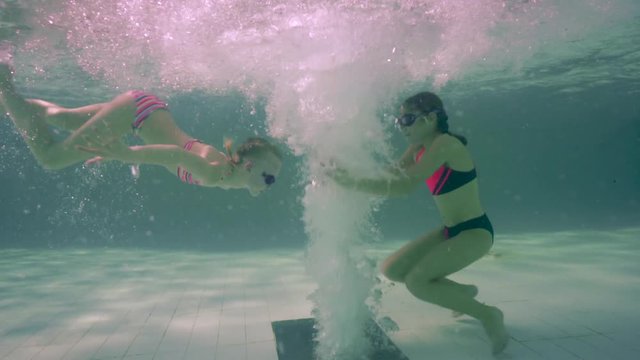Smiling girls in a warm bubble pool. Underwater. Jacuzzi.