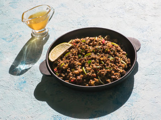 Indian minced meat Qeema on a sunny blue table. 