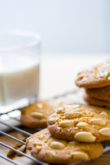 Peanut cookies on cooling rack with milk on wooden table