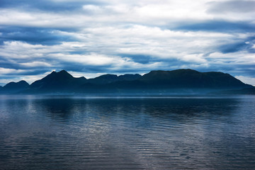 Fototapeta na wymiar Blue mountain over a fjord