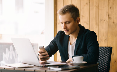 Stylish young man calling by the phone to solve business problems. Online consultation by phone. Freelancer discussing the development and planning of his online project. Outsourcing. Mobile services.