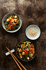 Vegetable in bowl stir fry on wok on concrete dark background