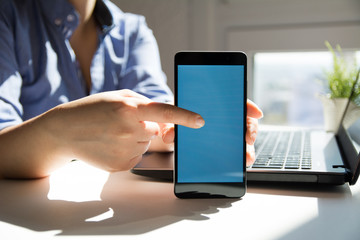 Woman hand holding a modern mobile smart phone with blank blue screen