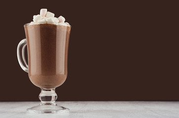 Autumn warm drink - hot cocoa with marshmallows  on dark brown background, copy space.