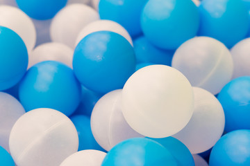 Close up of plastic white and blue balls in dry pool on the playground