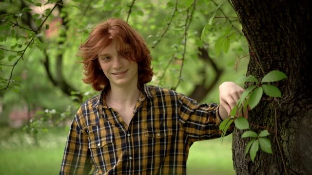 Young Guy With Long Red Hair in a Romantic Image in the Garden.