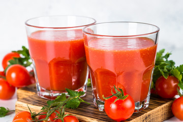 Tomato juice in glass on white.