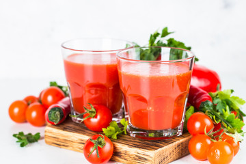 Tomato vegetable juice in glass on white.