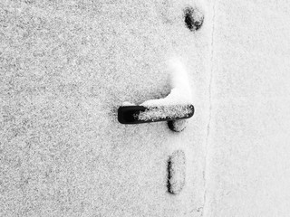 Door handle on the gate or gate is covered in snow in winter