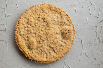 stylish cropped photo of a light brown cake located on the table. Minimalist style.