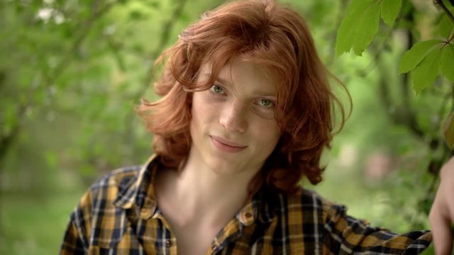 Young Guy With Long Red Hair in a Romantic Image in the Garden.