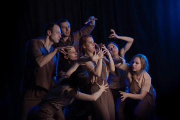 The actors on the stage play an emotion performance on a black background in stage light