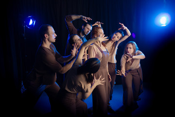 The actors on the stage play an emotion performance on a black background in stage light