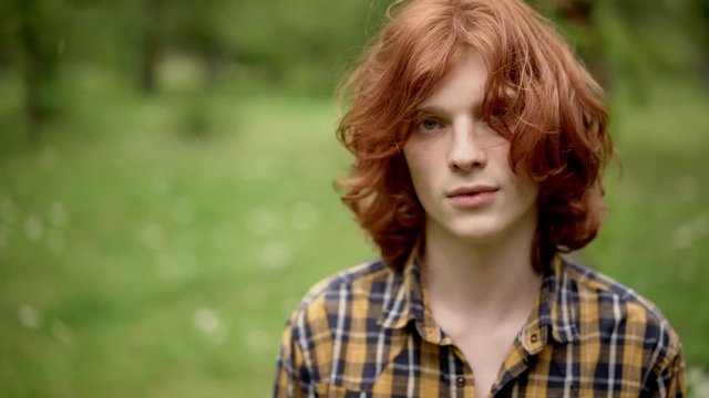 Charming guy with red hair smiles at camera.