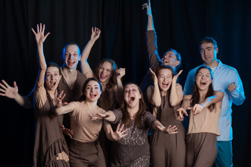 The actors on the stage play an emotion performance on a black background in stage light