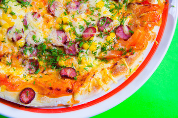 hot tasty fresh pizza on a plate close-up. green background