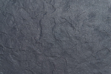 Grey matte uneven surface with glitter. Rough texture. Close up.