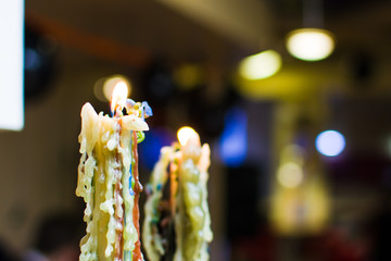 burning candle with streaks on the background of blurry lights
