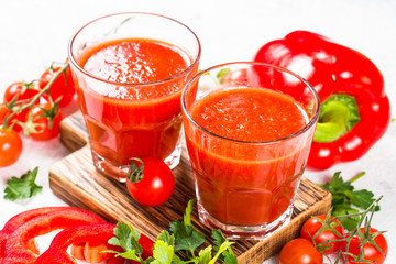 Tomato vegetable juice in glass on white.