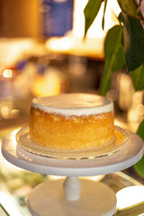 Stylish white cake standing on a cake stand on a high stalk