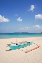 Boat docked on a beautiful tropical island beach.