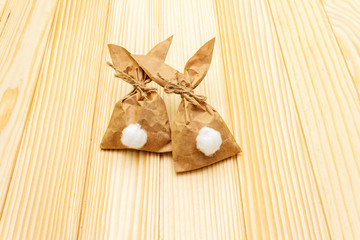 Easter bunny (rabbit) paper gift wrapping idea. Handicraft (homemade) concept for children (kids). On wooden background