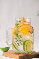 Infused water with lime, orange, apple and rosemary. Cold refreshing detox summer drink .Selective focus