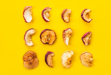Creative food knolling. Slices of organic sun dried fruits dehydrated apples on bright yellow background. Healthy diet wholefoods fall winter beverages ingredients concept. Flat lay. Poster banner