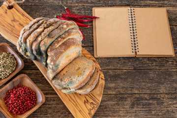 Moldy bread on the wooden rustic table , scarcity