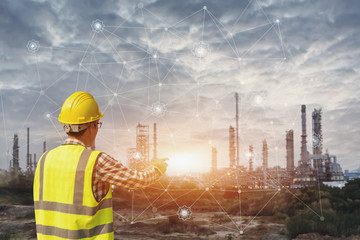 Businessman in safety helmet touching virtual interface screen .