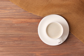 cup of coffee on wooden background top view.