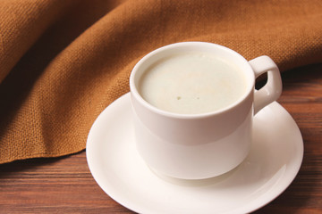 cup of coffee on wooden background top view.