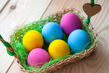 colored chicken eggs in a basket