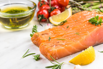 Cold smoked salmon fish fillets on white marble table
