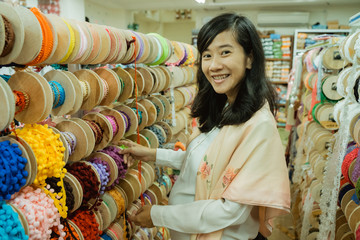 Obraz na płótnie Canvas young asian woman shopping some fabric decoration and accessories