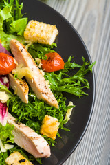 Healthy chicken salad with lettuce, grilled tomato, croutons, shredded cheese and grilled chicken